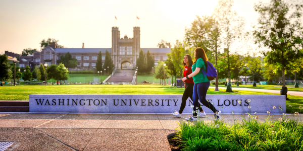 Two students walking in front of Washington University sign with Brookings Hall in the background