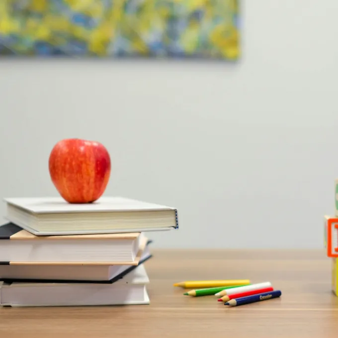 Books stacked with apple on top